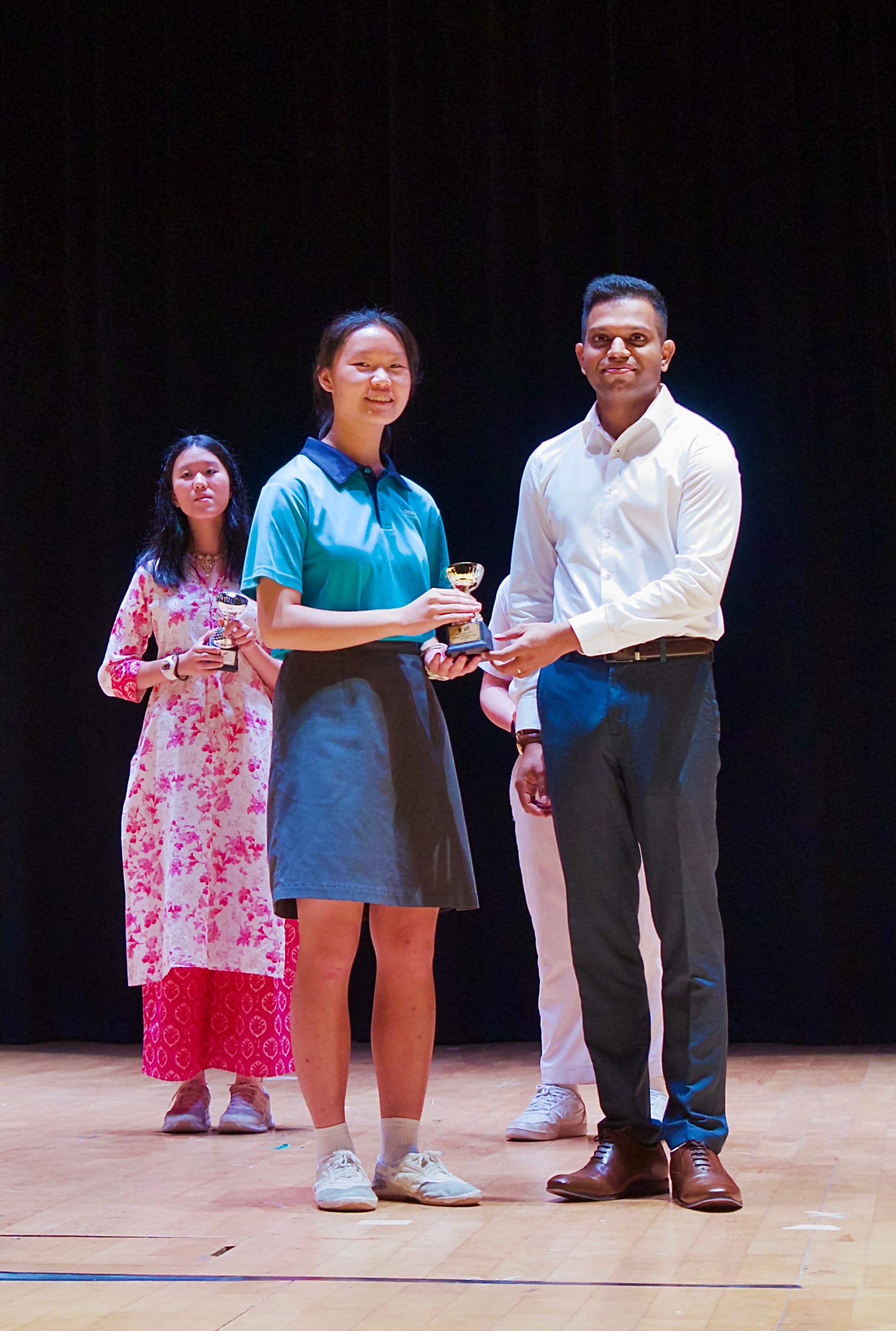 A girl receiving prize for tamil recital competition